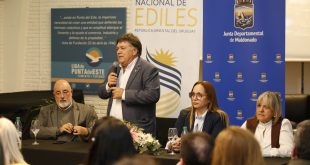 Hombre hablando en evento de turismo en Maldonado con panelistas.