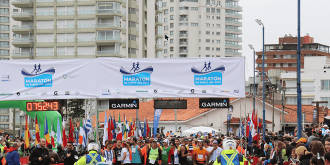 Largada de la Maratón de Punta del Este, con banderas y corredores en la salida